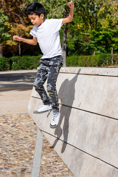 Young boy jumping while having fun in a park. Childhood concept. - Foto, Imagen