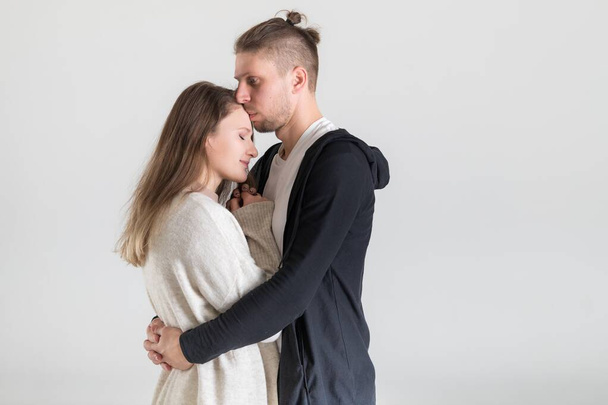 Portrait of a young caucasian couple hugging lovers on a white background. - Fotografie, Obrázek