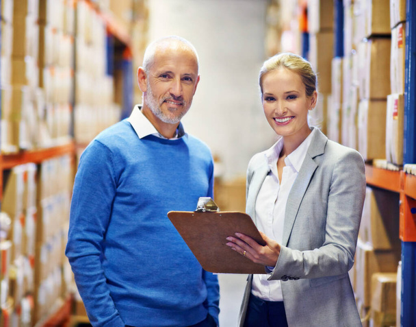We make an efficient team. Portrait of two people doing an inventory check in a warehouse - Foto, Imagem