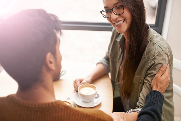 El amor está en el aire y huele a café. una joven pareja sentada en una cafetería en una cita - Foto, Imagen