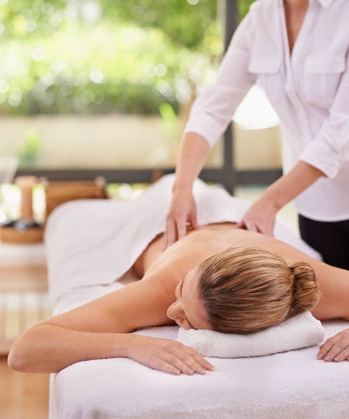 Experiencing total bliss. a woman in a day spa relaxing on a massage table - Foto, immagini