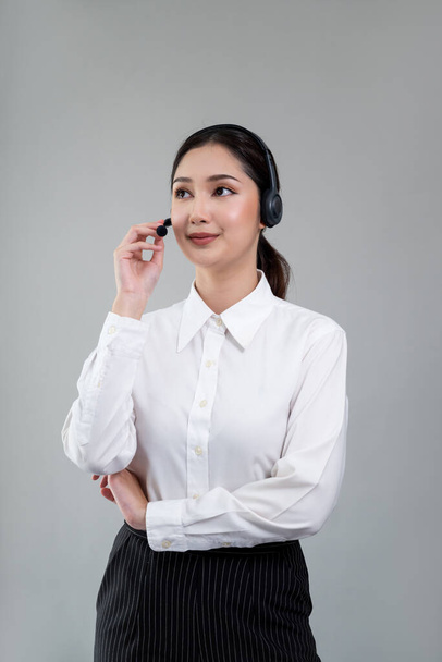 Attractive asian female call center operator with happy smile face advertises job opportunity on empty space, wearing a formal suit and headset on customizable isolated background. Enthusiastic - Fotografie, Obrázek