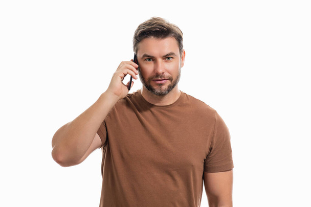 Portrait of a cheerful man using mobile phone isolated over studio background. Caucasian man using smart phone cellphone for calls, social media, mobile app. Online chatting. Guy talking on the phone - Foto, immagini