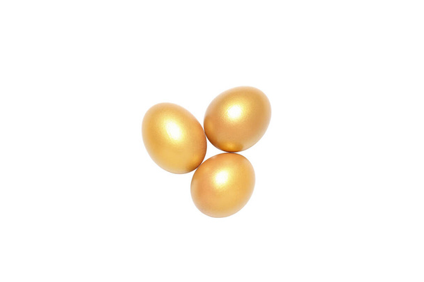 Концепция богатства и пенсии - золотые яйца, изолированные на белом фоне - Фото, изображение