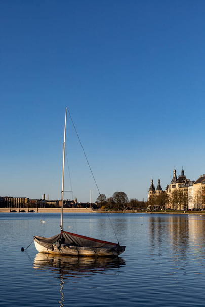 Kopenhag, Danimarka Peblinge Gölü ve konut binaları üzerinde muşambalı demirli bir salyangoz. - Fotoğraf, Görsel