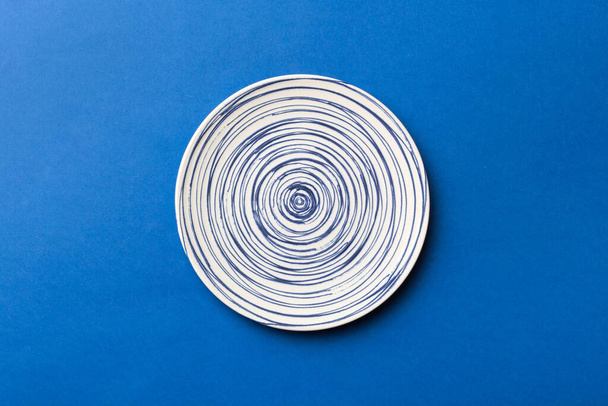 Vista superior de aislado de fondo de color vacío plato azul redondo para la comida. Plato vacío con espacio para su diseño. - Foto, Imagen