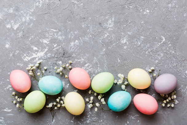 Feliz composición de Pascua. Huevos de Pascua sobre mesa de colores con gypsophila. Huevos coloridos teñidos naturales vista superior de fondo con espacio de copia. - Foto, imagen