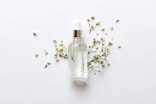 Fancy healthcare bottles for serum, micellar, tonic, toner, lotion, water and cream with gypsophila branch. Natural oranic spa cosmetics concept. Mockup, template, Top view. - Φωτογραφία, εικόνα