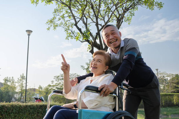 Ευτυχισμένο ζευγάρι ηλικιωμένων χαμογελώντας και χαλαρώνοντας στην πίσω αυλή - Φωτογραφία, εικόνα