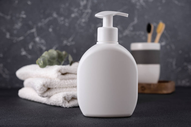 White empty shampoo or lotion bottle for mock-up in modern dark bathroom interior - Foto, Bild