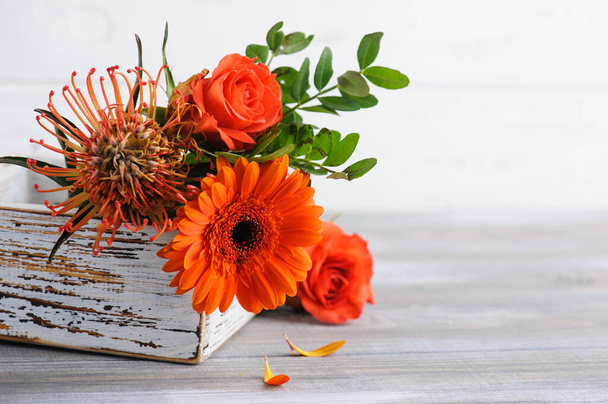 Autumnal orange red bouquet with rosa and gerbera flowers on white rustic background. Copy space for greeting cards and design - Photo, Image