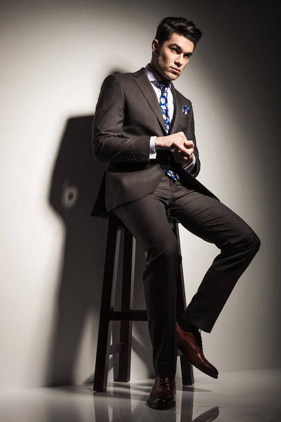 business man looking away while sitting on a stool - Photo, Image