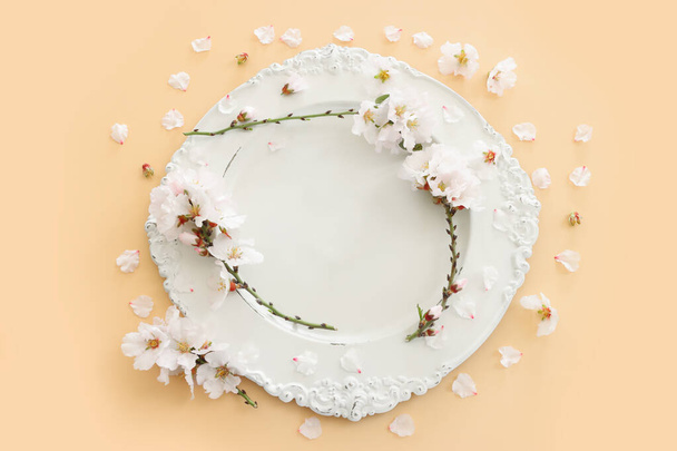 Top view of vintage white empty plate over spring cherry tree flowers. Flat lay - Foto, Imagen