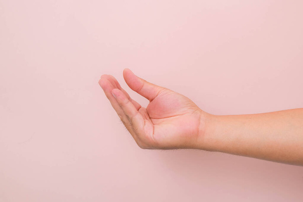 Geste der Hände, als würde man etwas Isoliertes auf rosa Hintergrund aufheben. - Foto, Bild