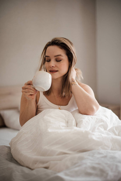 Portrait of young woman at morning in a bed. - Foto, Imagen