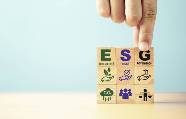 Επιχειρηματίας συγκεντρώνει ESG διατύπωση σχετικά με το ξύλινο κύβο μπλοκ για την αειφόρο ανάπτυξη οργάνωση και την ενσωμάτωση της έννοιας του περιβάλλοντος Κοινωνική Διακυβέρνηση.  - Φωτογραφία, εικόνα