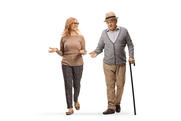 Elderly man with a cane and woman walking towards camera and talking isolated on white background - Photo, Image
