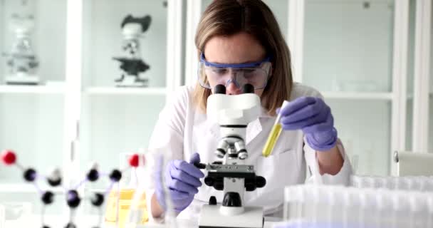 Wetenschappelijk laboratorium gele chemische stof in reageerbuis. Onderzoek en ontwikkeling op het gebied van kosmetische olie - Video
