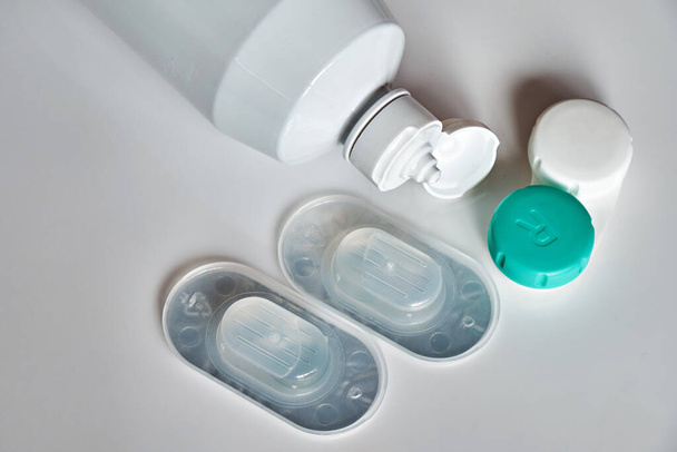 Packaged contact lenses, a bottle of cleaning fluid and a container for them. The topic of medicine and health care. - Foto, imagen
