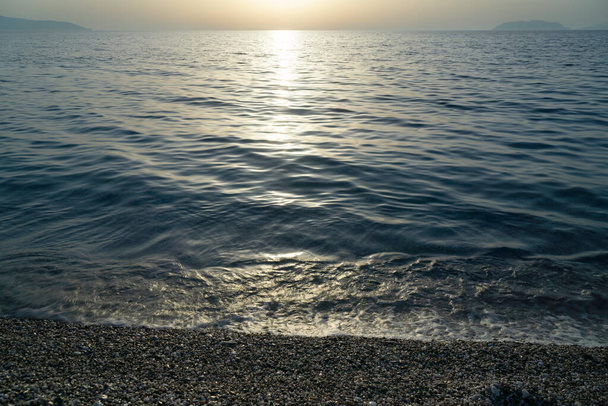 Beautiful scene of milazzo beach with mediterranean calm sea at golden hour - Fotó, kép