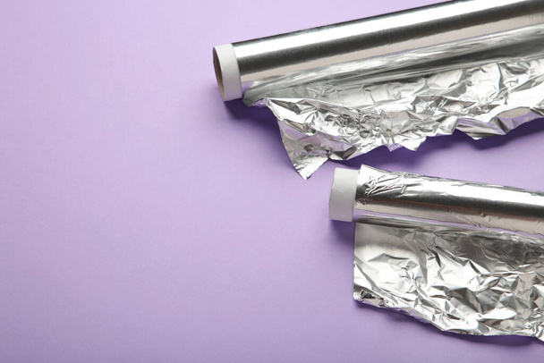 Roll of aluminum foil on purple background. Top view - Photo, Image