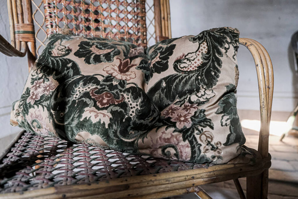 подушка на плетеном стуле в заброшенном доме. Высокое качество фото - Фото, изображение