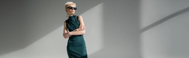blonde woman with fair-skin and tattoo posing in black sunglasses on grey background, banner  - Fotografie, Obrázek