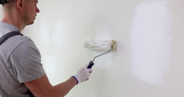 Close-up van kunstenaar hand schilderen muur met roller. Kwalitatief hoogwaardige muurschildering door een meesterbouwer - Video