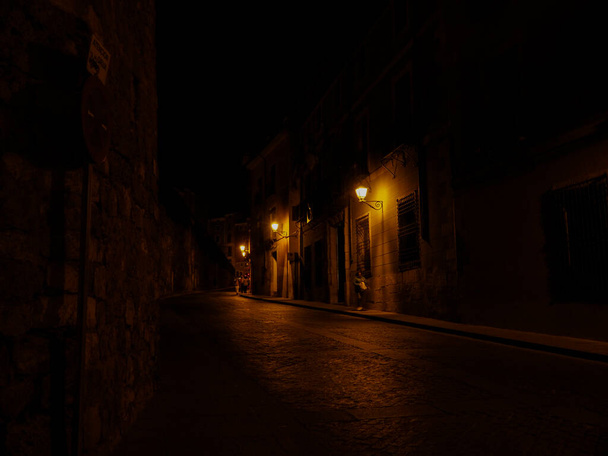 STREETS OF CUENCA CAPITAL AT NIGHT ILLUMINATED BY ITS WARM STREETLIGHTS - Foto, afbeelding