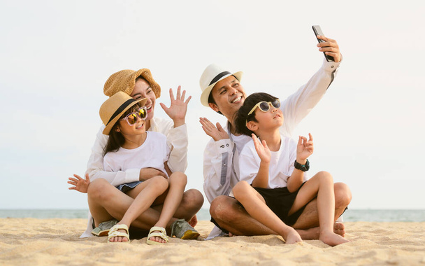 Mutlu bir aile babası, anne kız ve oğlu sahilde birlikte tatil yapıyor, plajda seyahat eden bir aile, tatilde sahilde birlikte seyahat eden mutlu bir Asyalı aile, sahil seyahati yapan bir aile, - Fotoğraf, Görsel