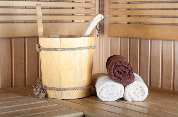 Традиційна дерев'яна сауна для відпочинку з відром води і
 - Фото, зображення