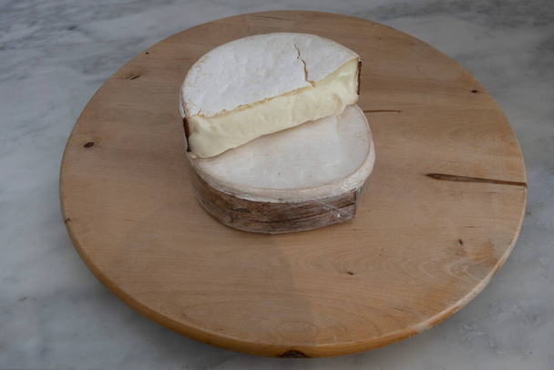 French culinary Still Life. Piece of cheese Lamanigodine placed on a wooden pan - Photo, Image