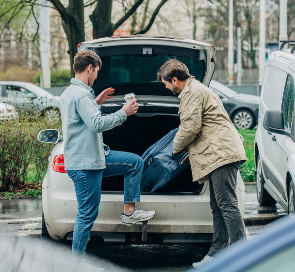 pai e filho colocaram a mala no porta-malas do carro, Wroclaw, Polônia - Foto, Imagem