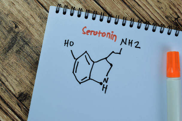 Έννοια της χημικής μοριακής μορφοποίησης ορμόνης σεροτονίνης γράψει στο βιβλίο που απομονώνονται σε ξύλινο πίνακα. - Φωτογραφία, εικόνα