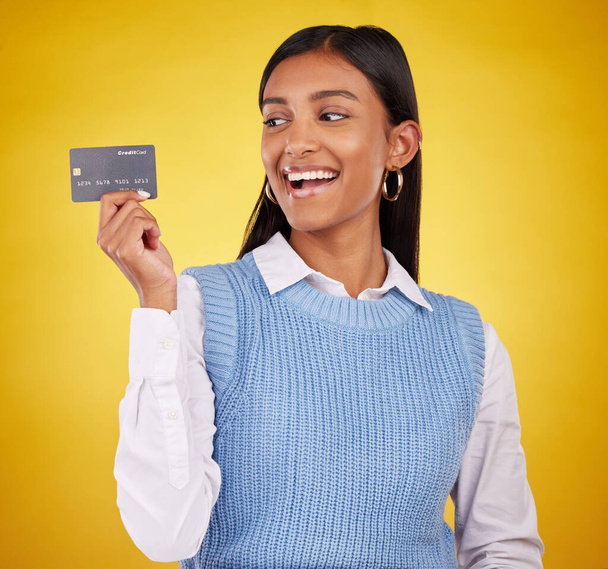Luottokortti, innoissaan ja intialainen nainen keltaisella taustalla pankki, investointi ja maksu studiossa. Pankkitoiminta mockup, rahoitus ja onnellinen tyttö muovi budjetti, kauppa ja edistäminen osto. - Valokuva, kuva