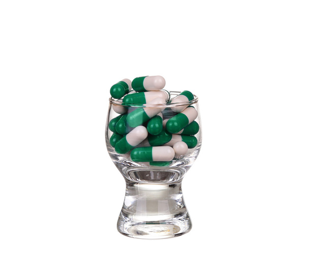 Un bicchiere di pillole e capsule su sfondo bianco
 - Foto, immagini