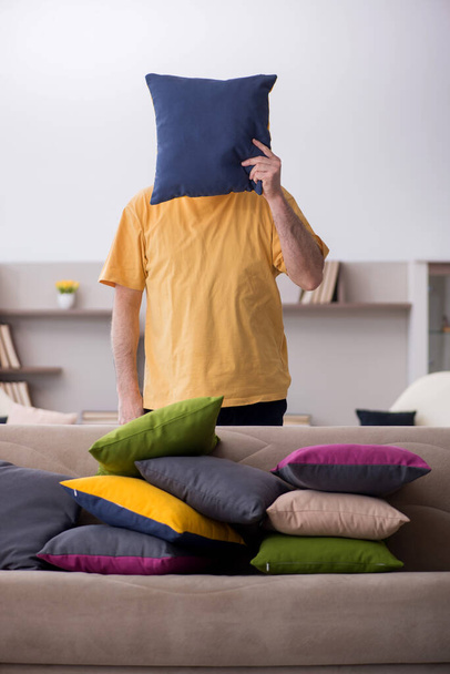 Ikääntynyt mies, jolla on monia tyynyjä kotona - Valokuva, kuva