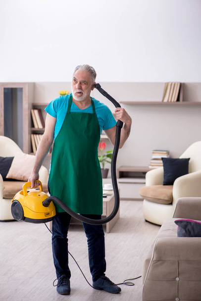 Old contractor cleaning the house - Foto, Imagen