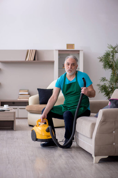 Old contractor cleaning the house - Foto, Imagen