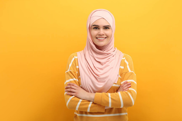 Portrait of Muslim woman in hijab on orange background - Foto, Imagem