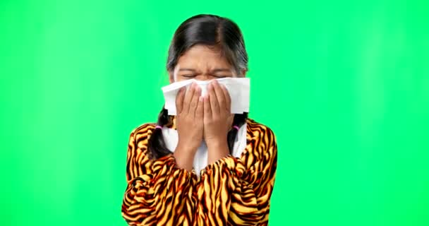 Niños, covid y sonarse la nariz con una chica en un fondo de pantalla verde que sufre de alergias. Retrato, niños y enfermos con una niña pequeña estornudando por infección, polen o fiebre del heno. - Metraje, vídeo