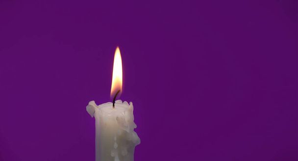 Immagine delle dimensioni dello striscione di una candela accesa su uno sfondo viola con spazio di copia gratuito per il testo - Foto, immagini