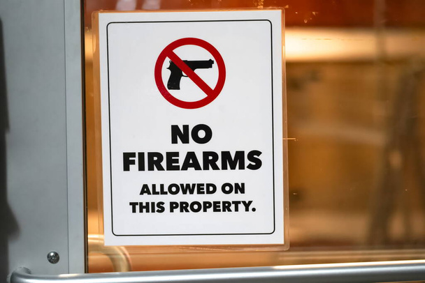 Close-up de Não são permitidas armas de fogo no sinal da propriedade na janela da loja proibindo arma de propriedade privada. - Foto, Imagem