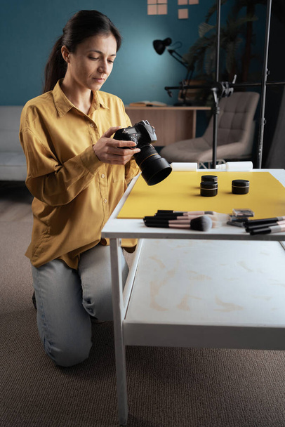 Fotógrafa profissional fotografando produtos de beleza na mesa em seu estúdio em casa. Fotografia e maquiagem blogging. Espaço de cópia - Foto, Imagem