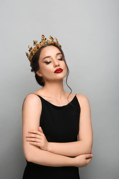 Beautiful young woman wearing luxurious crown on light grey background - Foto, Imagem
