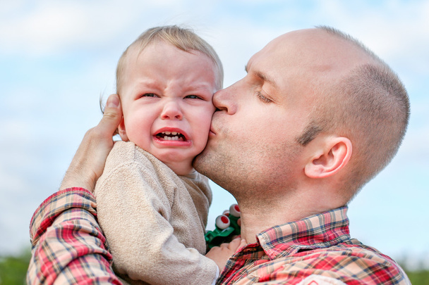 caring father calms toddler son outdoors  - Photo, Image