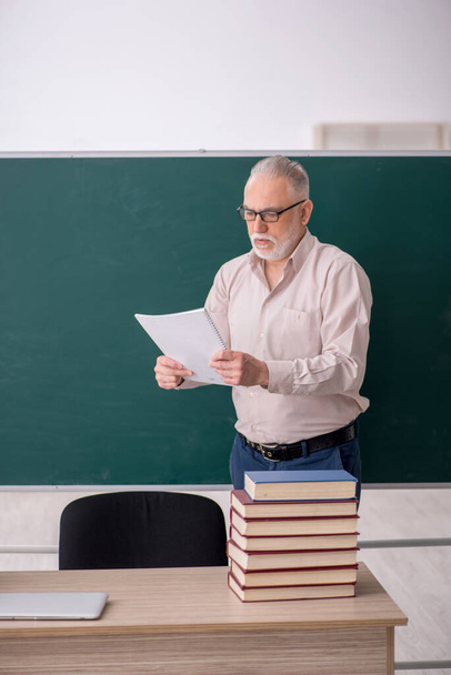 Old teacher sitting in the classroom - Foto, immagini