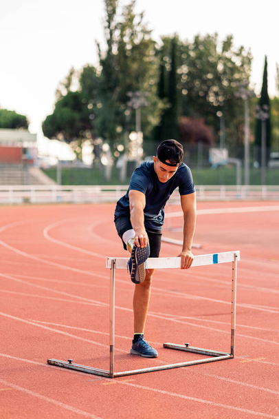 Disabled man athlete stretching with leg prosthesis. Paralympic Sport Concept. - Foto, Imagem