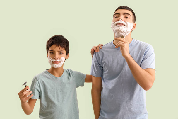 Человек и его маленький сын бреются на светлом фоне - Фото, изображение