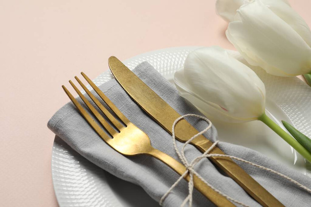 Stylish table setting with cutlery and tulips on pink background, closeup - Foto, immagini